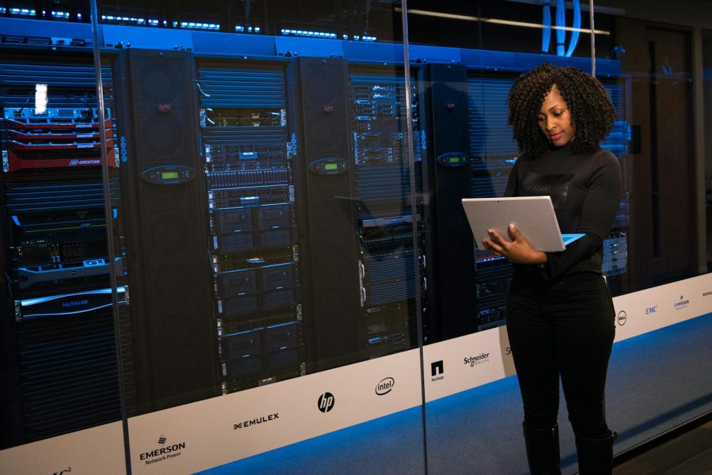 DepEd Partners with DOST for STEM Revolution, Scientific Innovations Underway 5 A female engineer using a laptop while monitoring data servers in a modern server room.