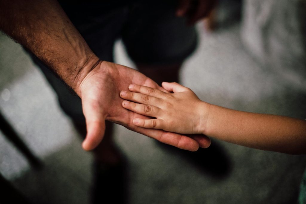It's His Late Father's Dream for Him: Son of Construction Worker Ranks 10th in Engineering Board Exam 6 Close-up of a child's hand resting gently on a man's hand, symbolizing love and support.