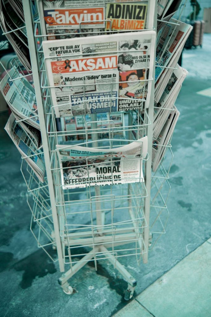 Craft Superior Stories: 12 Point Checklist to Write Straight News Article for a Tabloid 5 Vertical shot of a street newspaper stand displaying various printed newspapers.