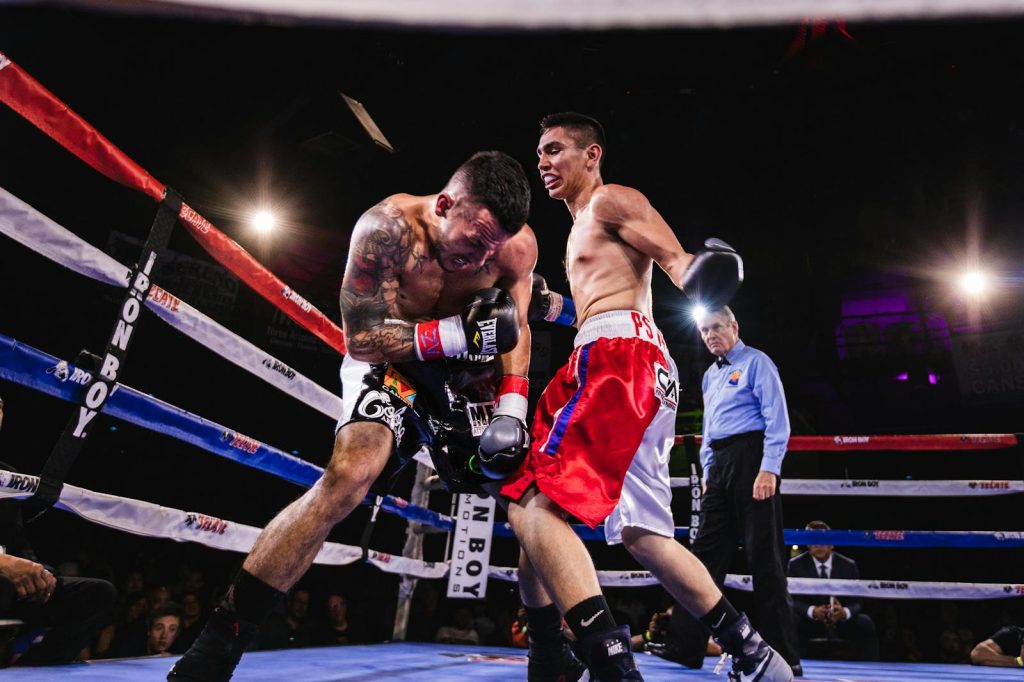 13 Actionable Game Plan to Kick Butt Sports News for Online News Page 7 A dynamic scene of two boxers in action during a fierce match in the boxing ring.