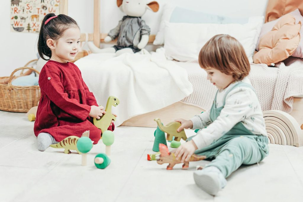 10 No Nonsense Classroom Management Strategies for Preschool Learners in the Digital Age 6 Two kids playing with wooden toys in a cozy playroom setting, indoors.