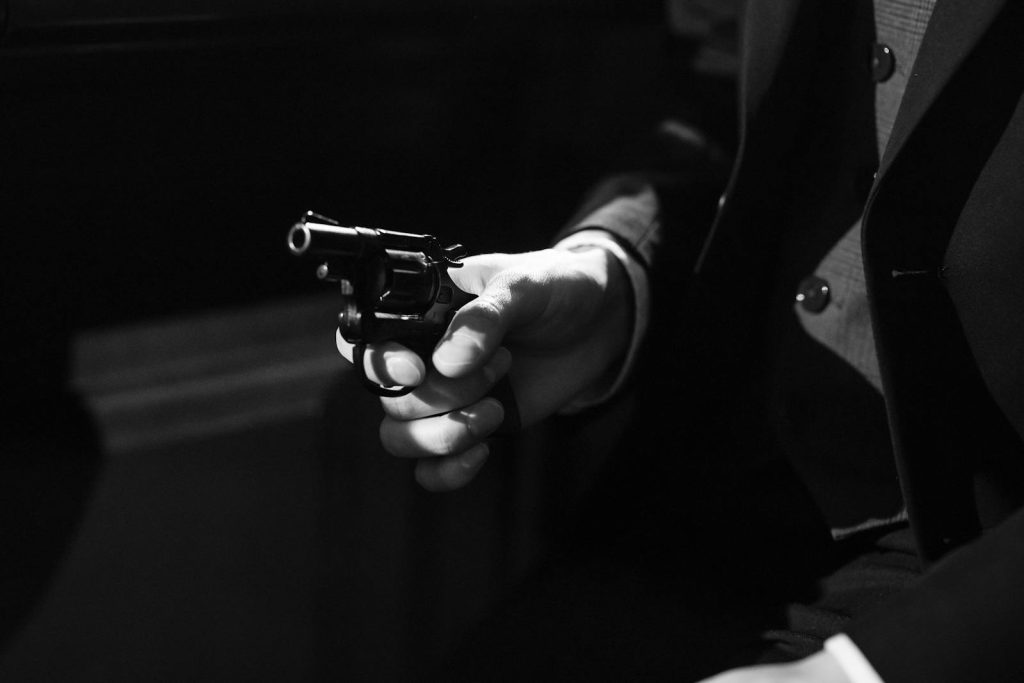 10 Brutal Strategy to Slay Writing Crime-Related News Article for Bootleg Output 7 Black and white image capturing a suspenseful noir scene with a handgun.
