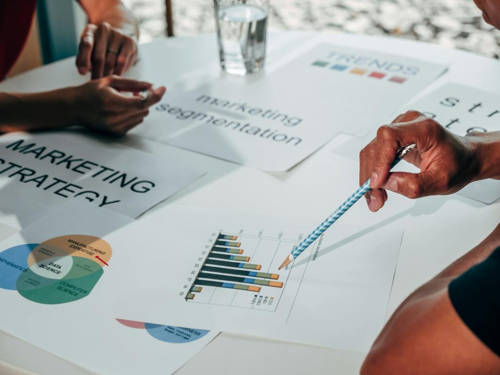 6 Crackerjack Practices to Finding the Perfect Niche on Your Online News Platform 8 Team working on marketing strategy using data charts and papers in an office meeting.