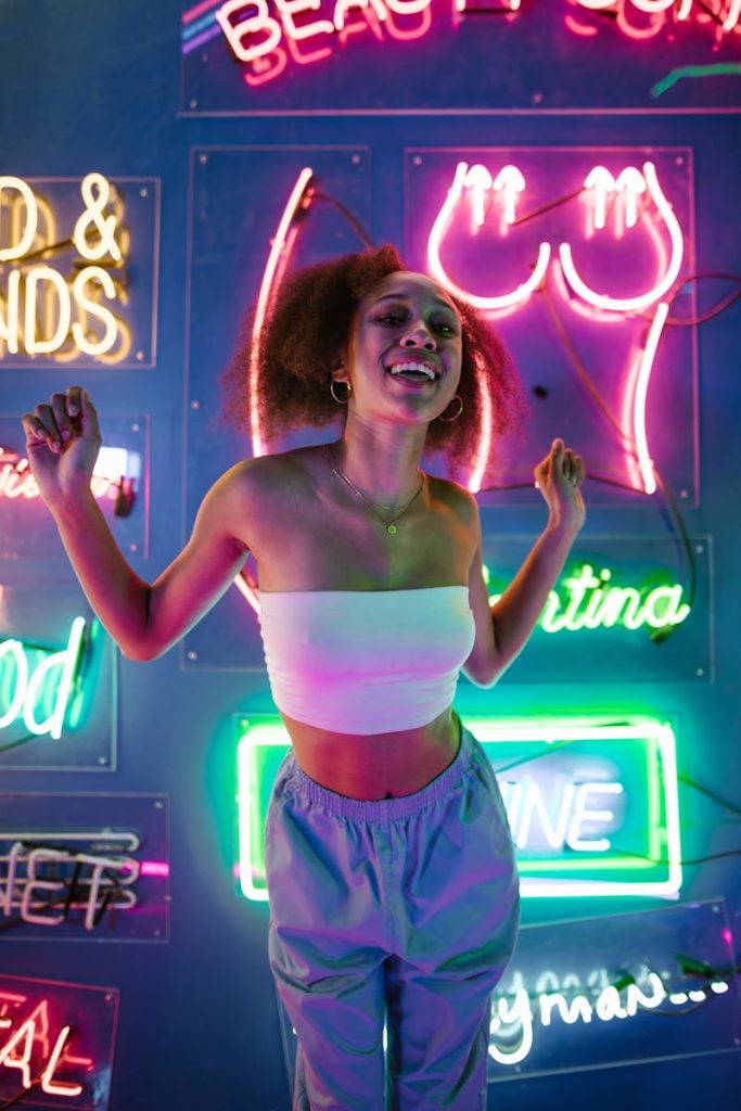 7-Point Checklist to Create Feature Articles that Goes Viral on Social Media in 7 Minutes 5 A young woman enjoying nightlife surrounded by colorful neon lights in a club setting.