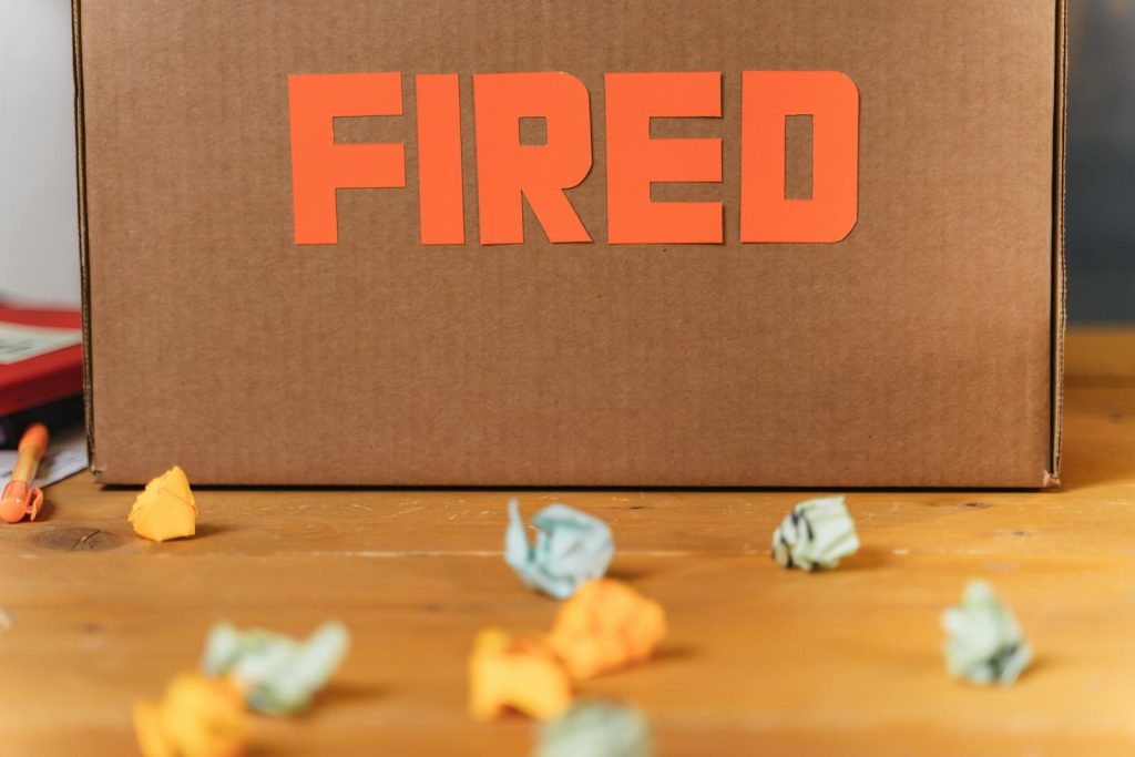 Sampaguita Girl Wants to Apologize to Security Who Lost Job After Their Viral Mall Confrontation 7 Close-up of a cardboard box labeled FIRED on a wooden table with crumpled papers.
