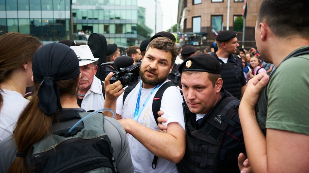 man in white tank top with black backpack