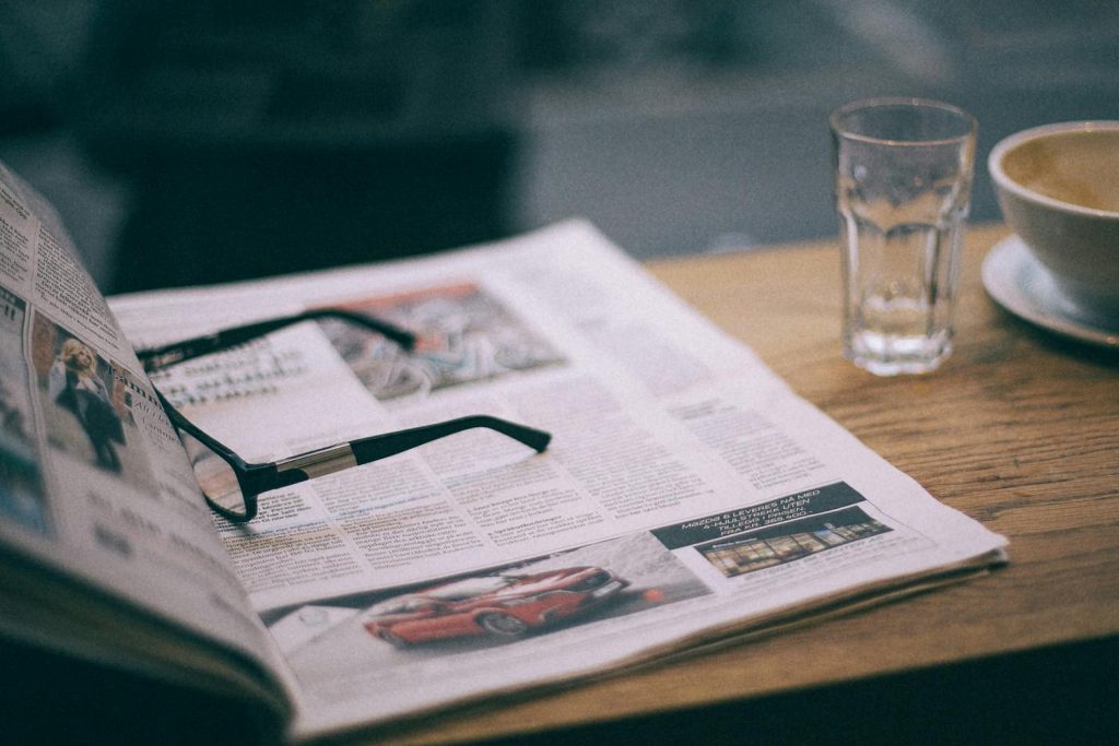 9 Incredibly Great Column Writing Tips to Produce a Noteworthy Article 5 Eyewear on magazine with text in columns and illustrations near cup with saucer on wooden table in cafeteria