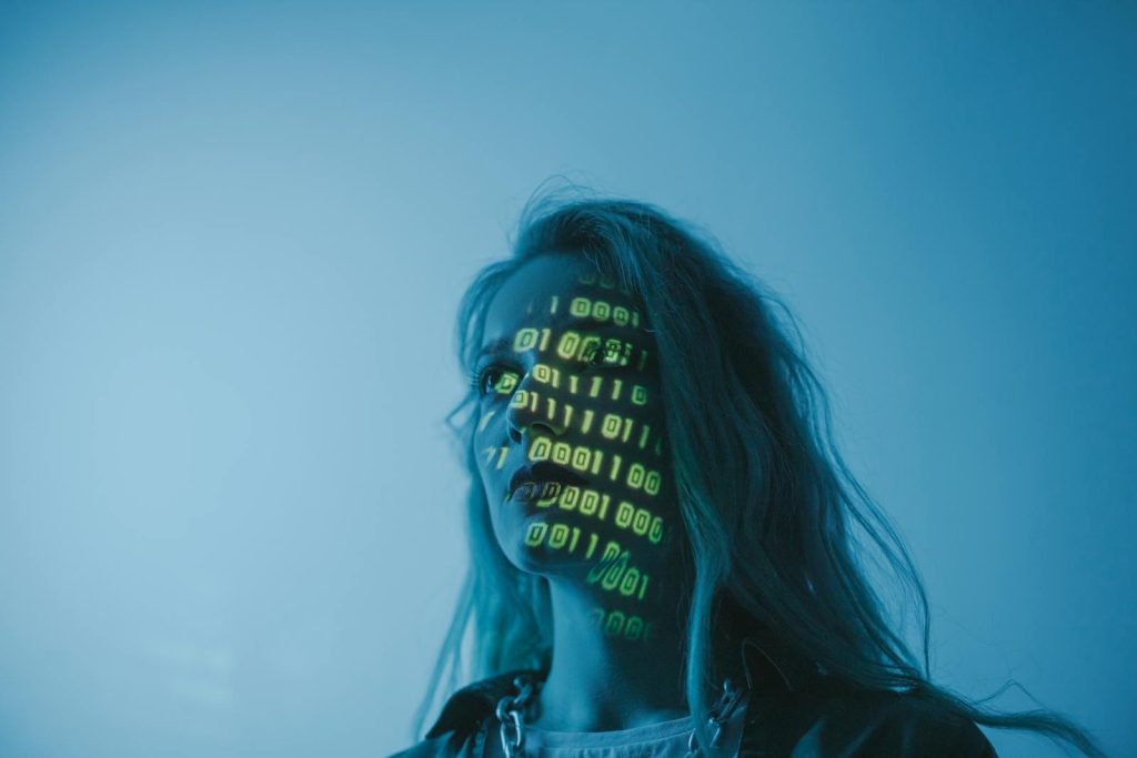 An Ally or Adversary: Why the Impact of Artificial Intelligence in the Country Should Concern You? 5 A woman with binary code lights projected on her face, symbolizing technology.