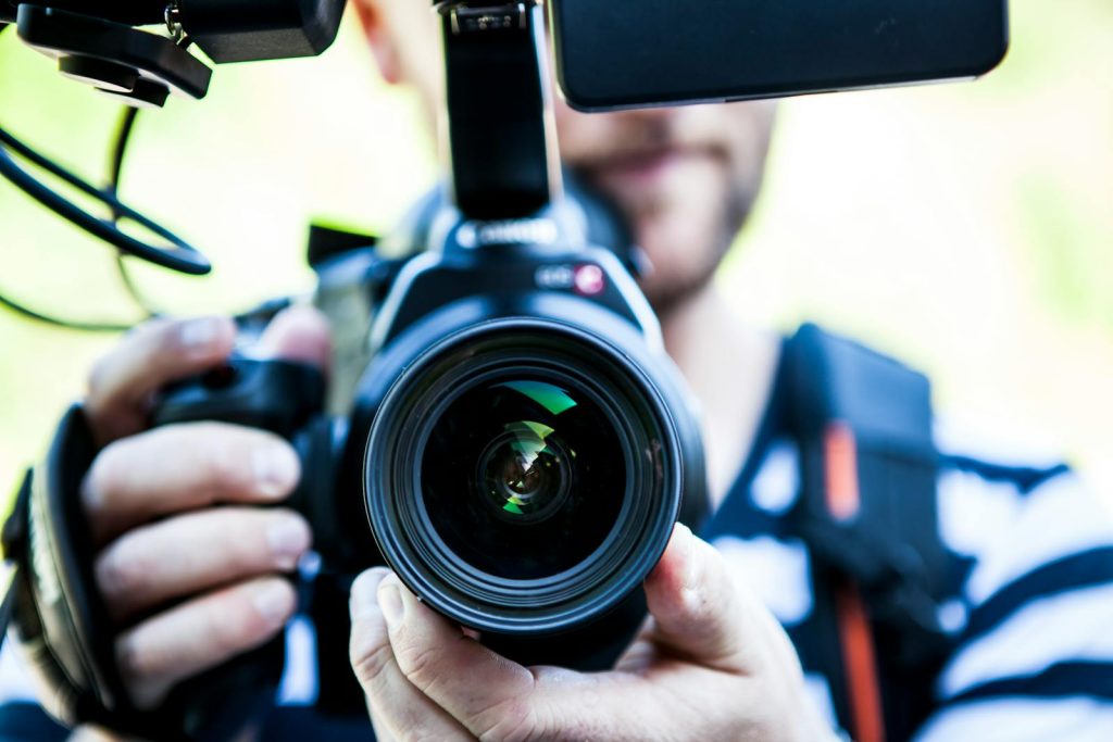 10 Tips to Dominate Your Next ScieTech Writing Contest and Triumph in NSPC 7 A close-up shot of a cameraman filming, focusing on the camera lens and equipment.
