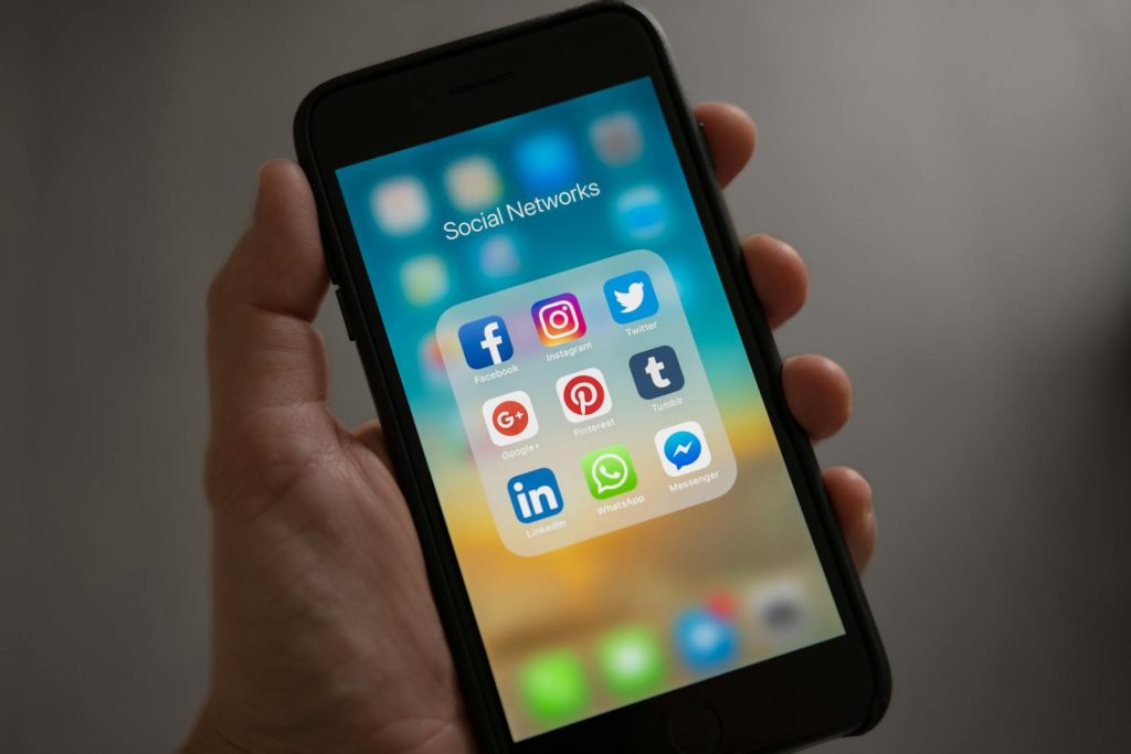 Definitive Proof that Filipinos Need Reliable Internet Speed, Can We Keep Up? 7 A smartphone displaying various social media icons held in a hand, showcasing modern communication apps.