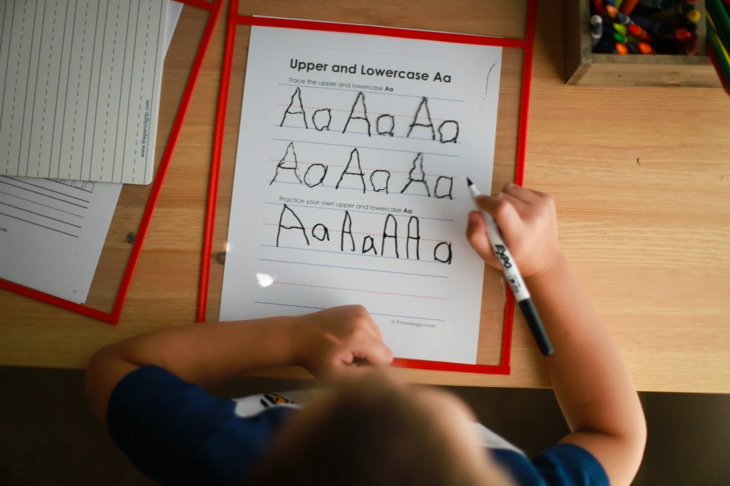 This is a Sure-Fire Formulas To Help Students with Dyslexia Read 5 a young boy writing on a piece of paper