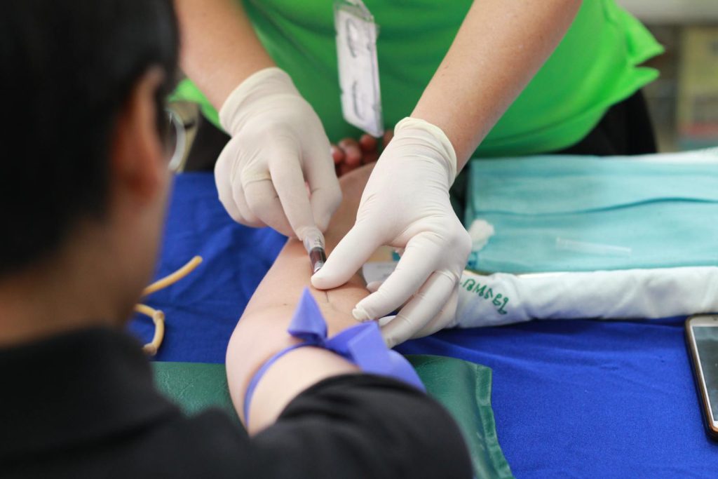 He Mastered Over 8000 Nursing Flashcards and Studied 8-12 Hours Daily to Top the Nurse Board Exam 6 A healthcare professional administering an injection to a patient's arm during a medical procedure.