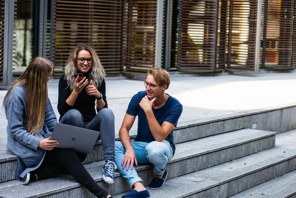 5 Easy Steps to Using the Pomodoro Technique, Game-Changing Tool For Procrastinators 9 Three young professionals having a friendly chat while sitting on outdoor steps.
