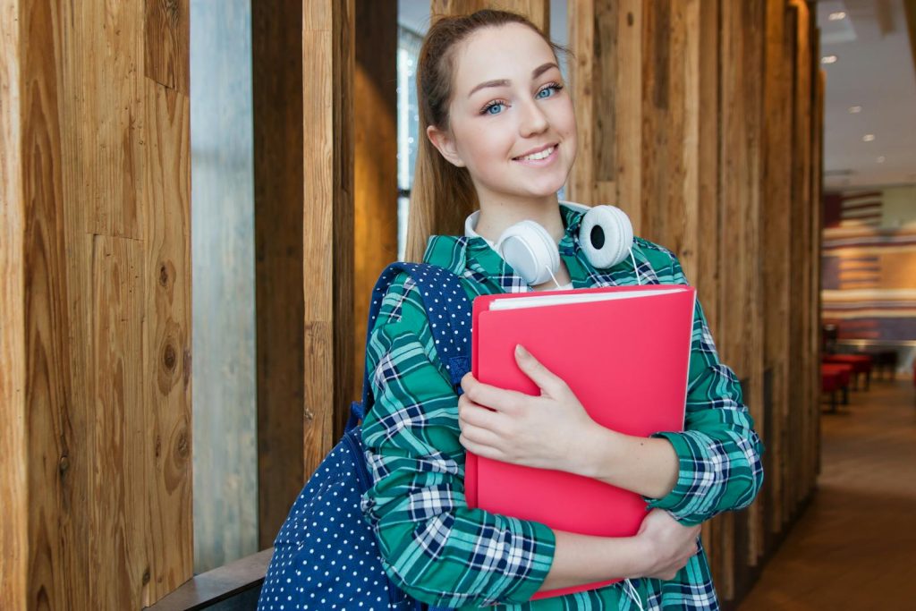 Beat the Forgetting Curve, Become a Memory Champ. Spaced Repetition is the Technique to Build Long-Term Understanding 5 Smiling student holding book and wearing headphones, ready for study.