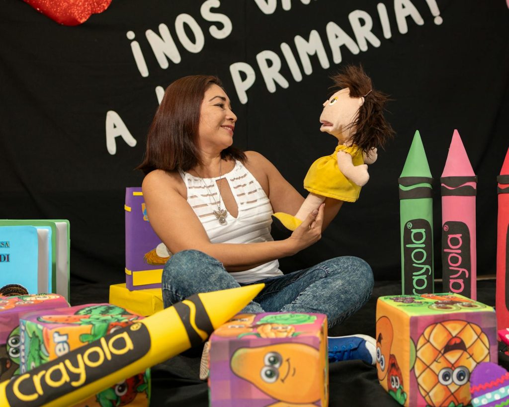 Heavy Workload and Excessive School Decorations Lead to Poor Student Performance in the Philippines? 7 A cheerful teacher using a puppet in a creative educational setting, inspiring young minds.