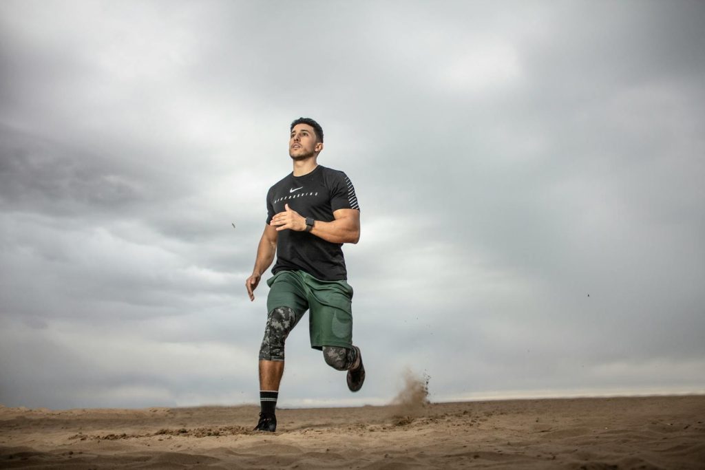How Physical Exercise and Memory Workouts Boost Memory, Concentration According to Science 7 A muscular man running on sandy terrain under cloudy skies, promoting fitness and adventure.