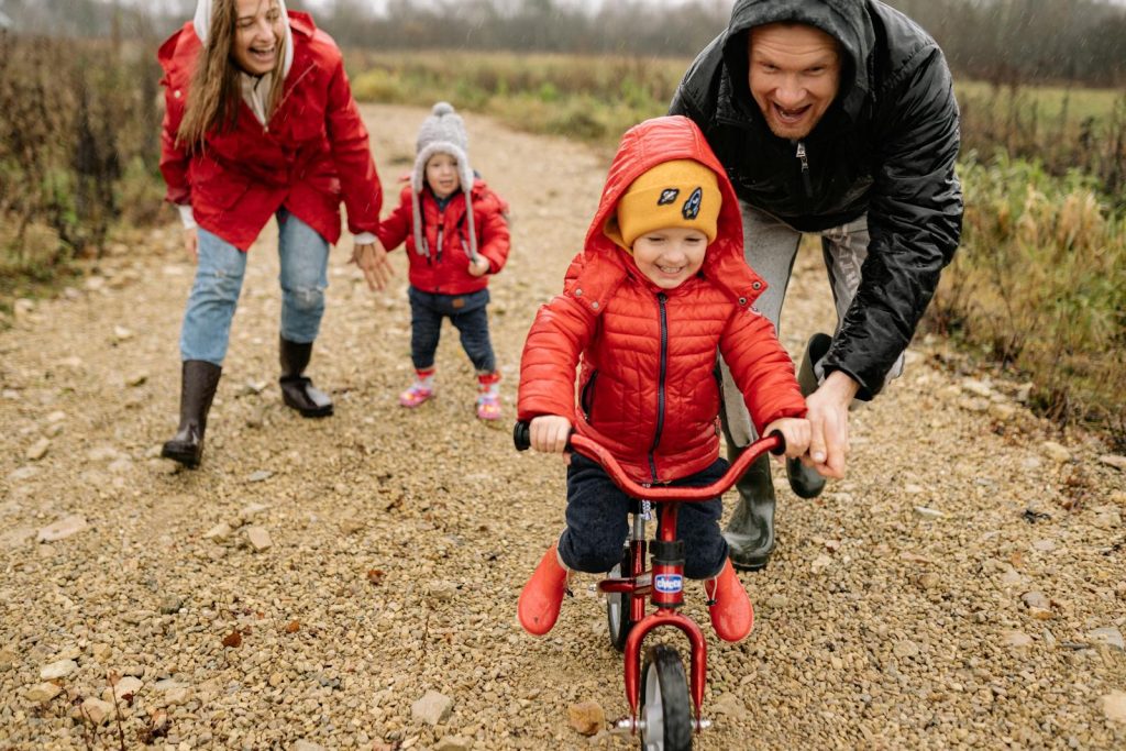 Farmer Parents Patiently Wait for Demo Teacher Daughter to Finish Demo Teaching - Priceless Act 5 Parents teaching kids to ride bikes outdoors in fall, enjoying family bonding and fun.